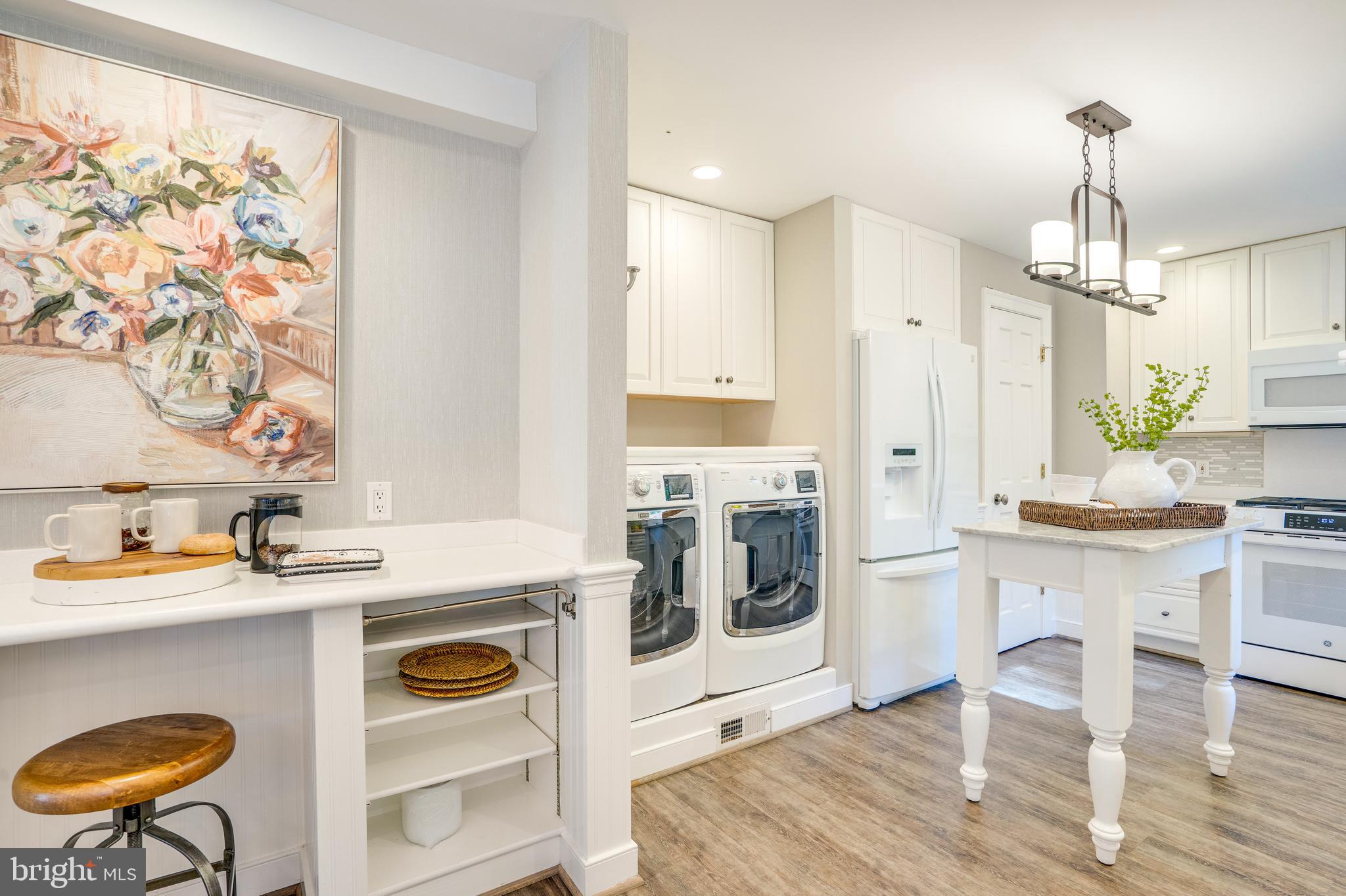 2603 Penny Royal Lane Reston, VA 20191 - Photo 20 of 72 a kitchen with stainless steel appliances granite countertop a stove a sink a microwave a refrigerator and white cabinets with wooden floor