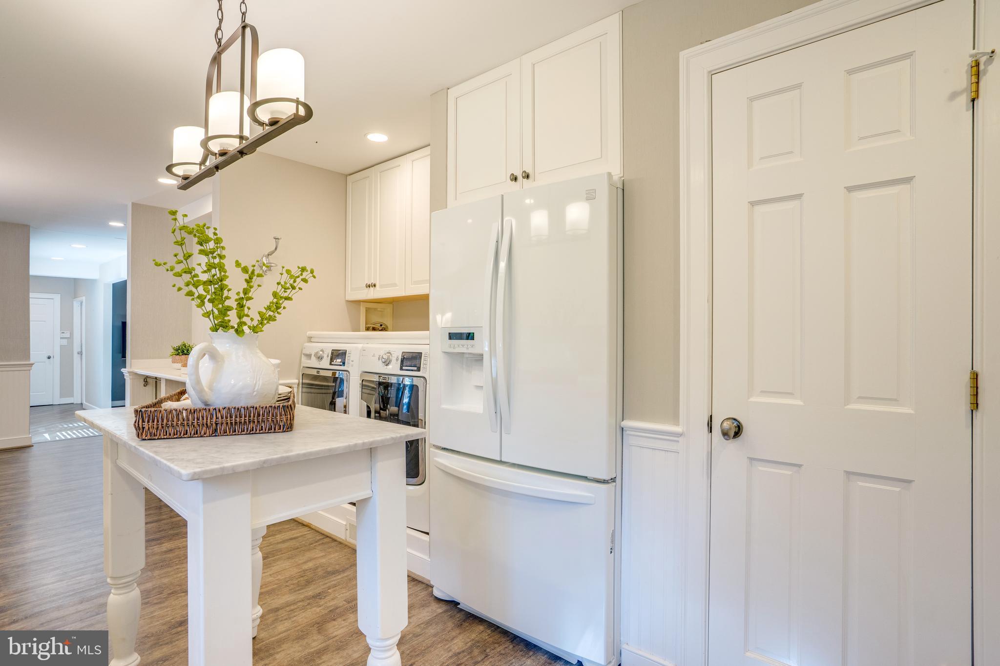 2603 Penny Royal Lane Reston, VA 20191 - Photo 23 of 72 a kitchen with stainless steel appliances kitchen island granite countertop a refrigerator a stove and white cabinets with wooden floor
