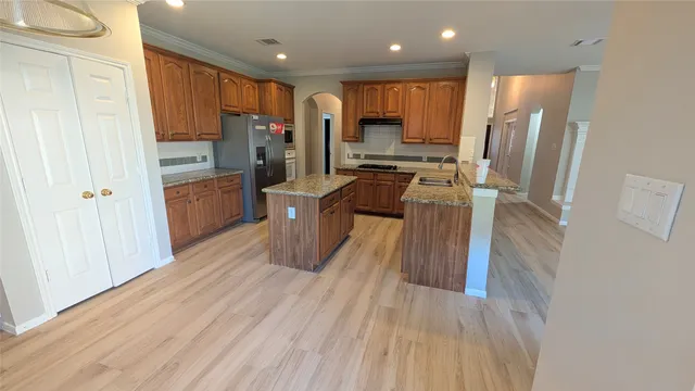 a kitchen with stainless steel appliances a refrigerator and a stove top oven