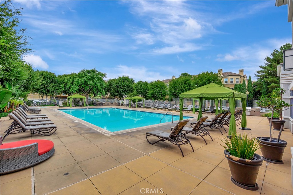 3405 South Main Street, Unit D Santa Ana, CA 92707 - Photo 26 of 30 a view of a swimming pool with lawn chairs under an umbrella