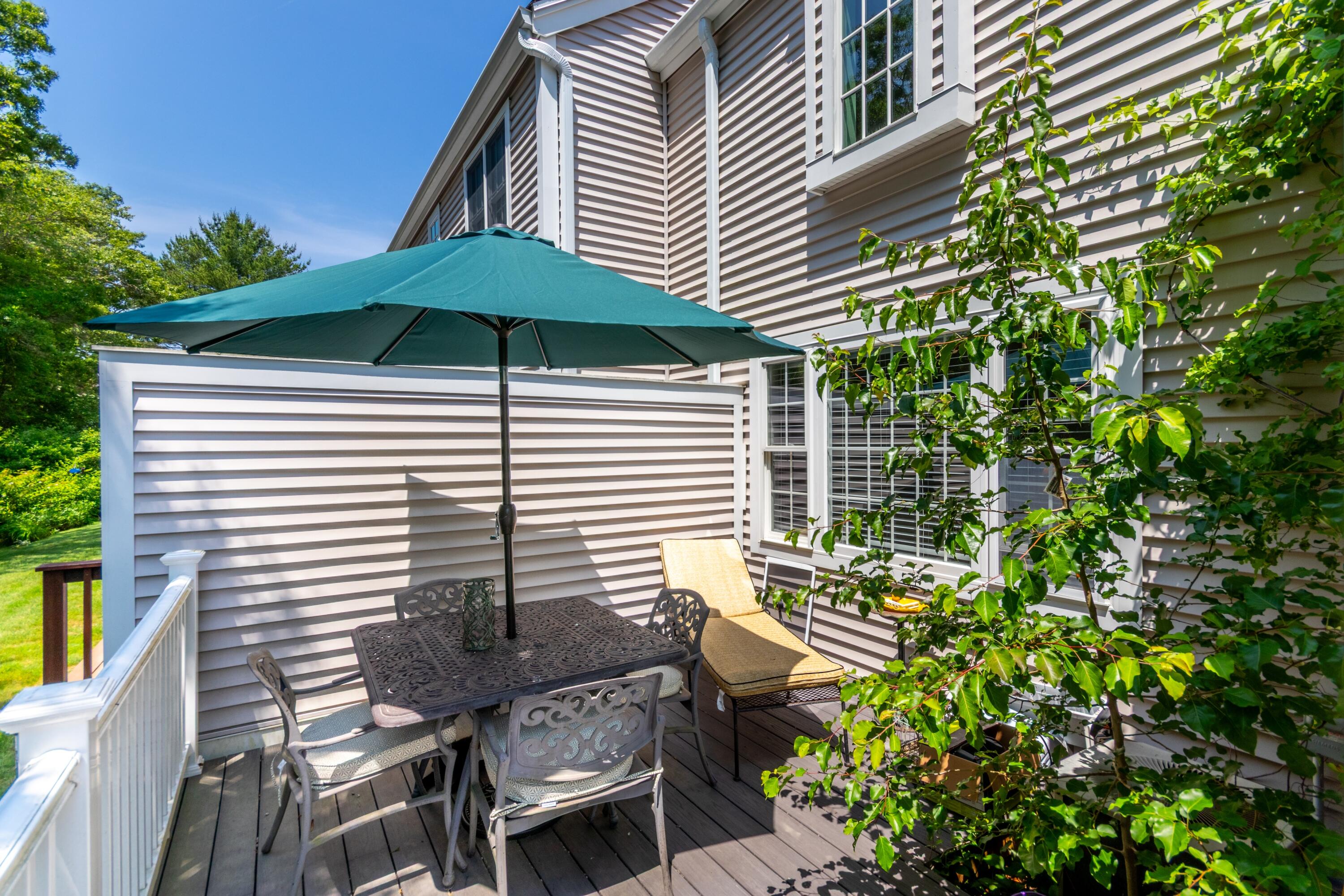 15 Hampton Court, Unit 15 Mashpee, MA 02649 - Photo 33 of 40 a backyard of a house with table and chairs
