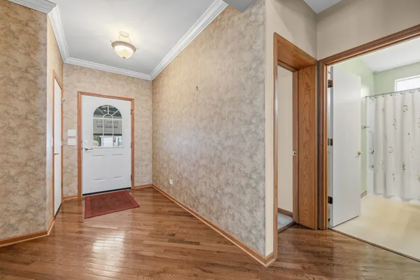 a view of a hallway with wooden floor and closet