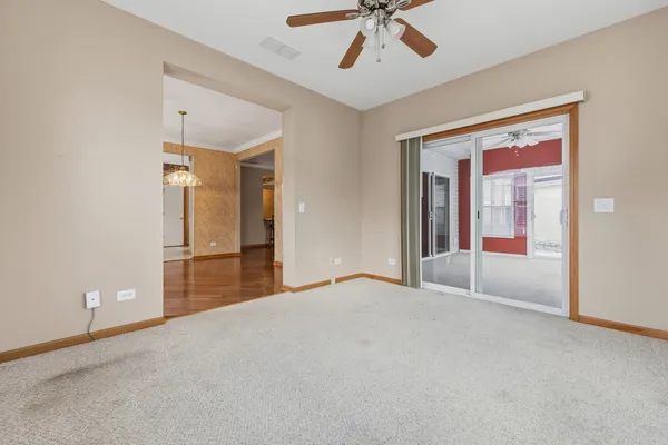 a view of empty room with chandelier fan and a rug