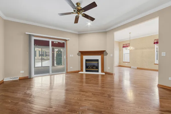 a view of an empty room with window and wooden floor