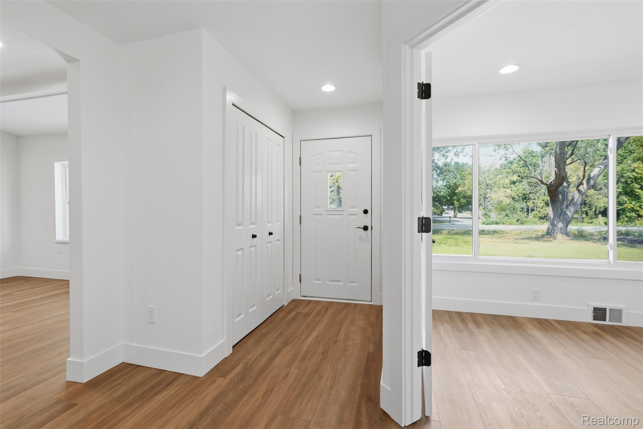4655 Denton Road Canton, MI 48188 - Photo 6 of 54 Entryway featuring wood-finish flooring, white walls, built-in closet with bifold doors, and a paneled front door with decorative glass