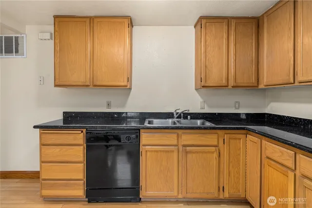 a kitchen with granite countertop cabinets and black appliances