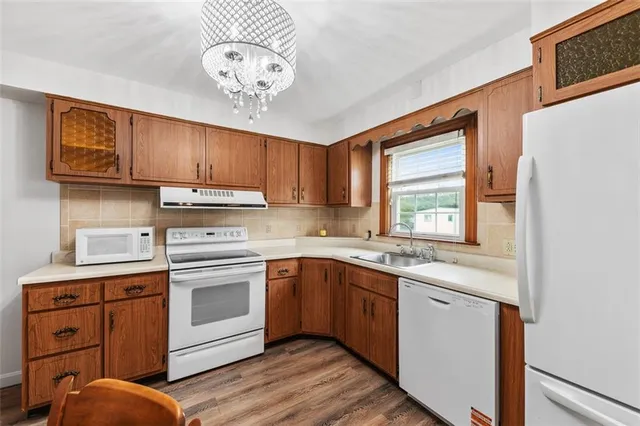 a kitchen with cabinets wooden floor and stainless steel appliances