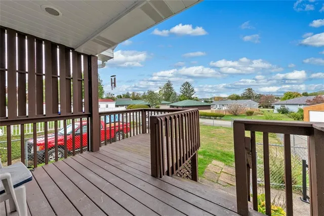a view of a balcony with wooden floor & fence