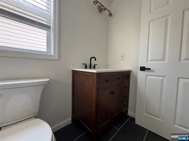 a bathroom with a toilet a sink a vanity and mirror