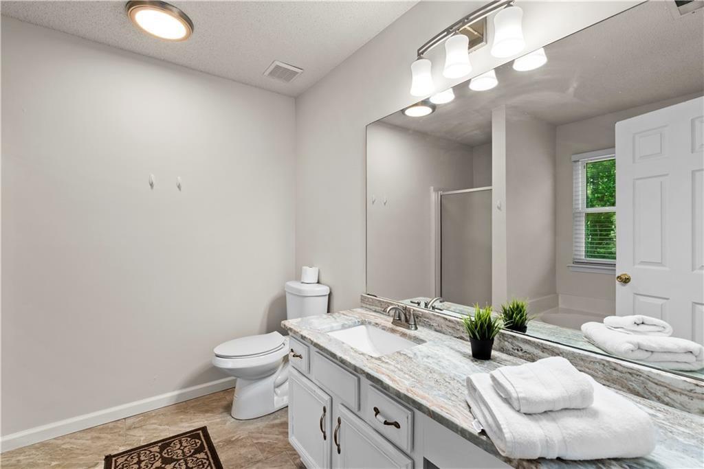 1700 English Ivey Lane Kennesaw, GA 30144 - Photo 24 of 29 a bathroom with a granite countertop sink mirror and toilet