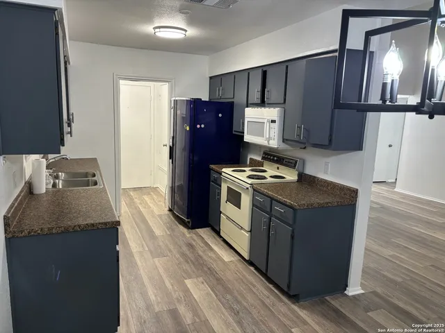 a kitchen with stainless steel appliances granite countertop a refrigerator and a stove
