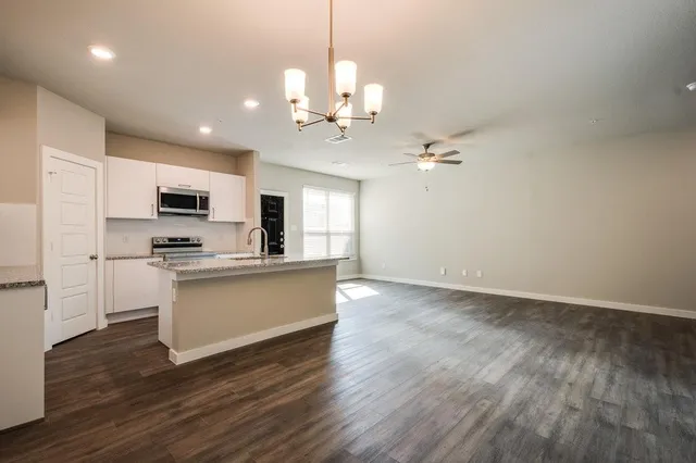 a view of kitchen with sink microwave and refrigerator