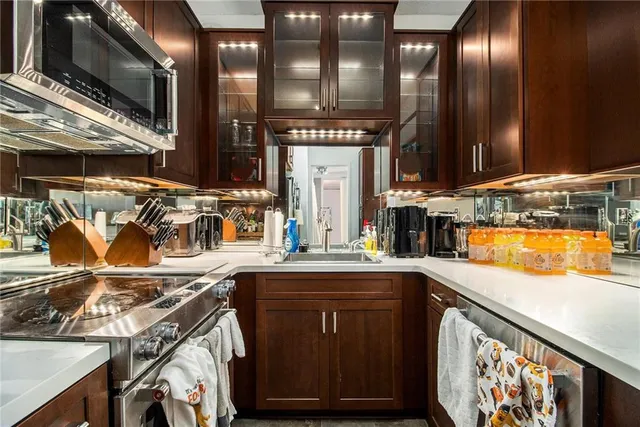 a kitchen with stainless steel appliances granite countertop a sink a stove and a microwave