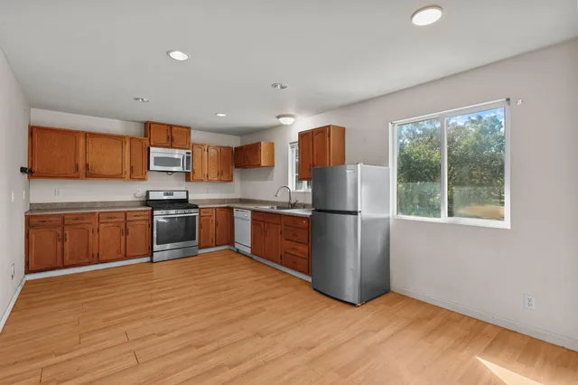 a kitchen with stainless steel appliances a refrigerator and a stove top oven