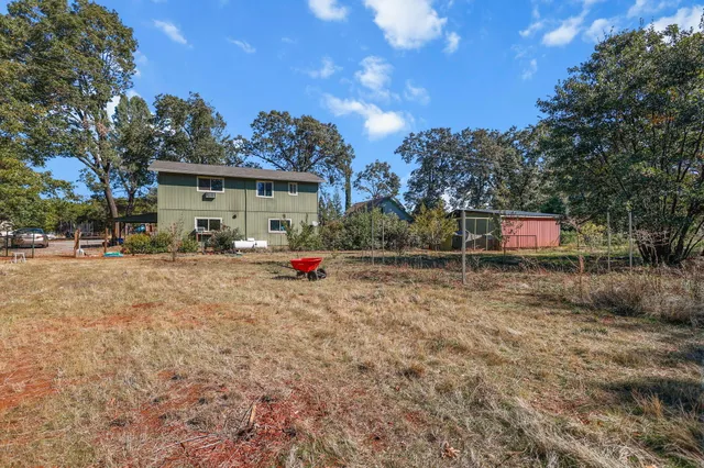 a backyard of a house with table and chairs