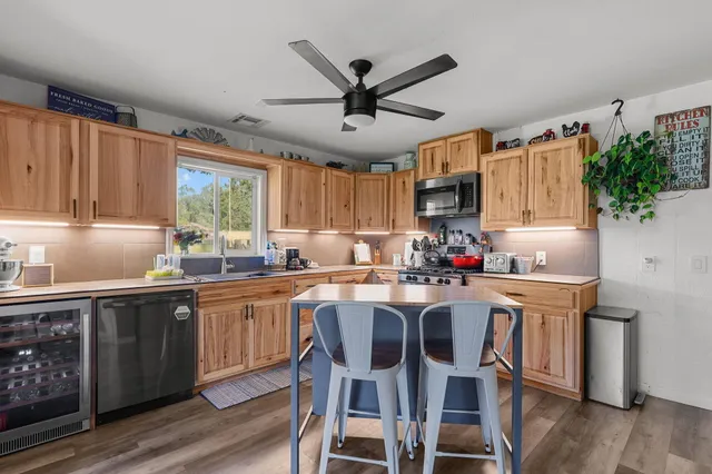 a kitchen with granite countertop cabinets stainless steel appliances dining table and chairs
