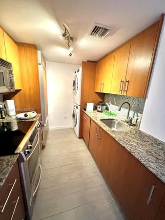 a kitchen with stainless steel appliances granite countertop sink stove and refrigerator