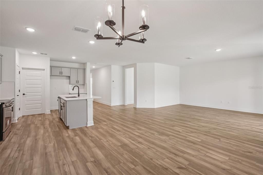 3033 Magellan Avenue Spring Hill, FL 34608 - Photo 11 of 42 a view of kitchen and empty room with wooden floor