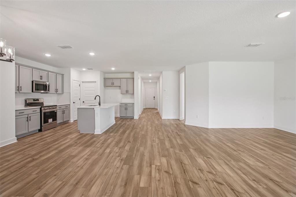 3033 Magellan Avenue Spring Hill, FL 34608 - Photo 13 of 42 a large kitchen with cabinets and stainless steel appliances