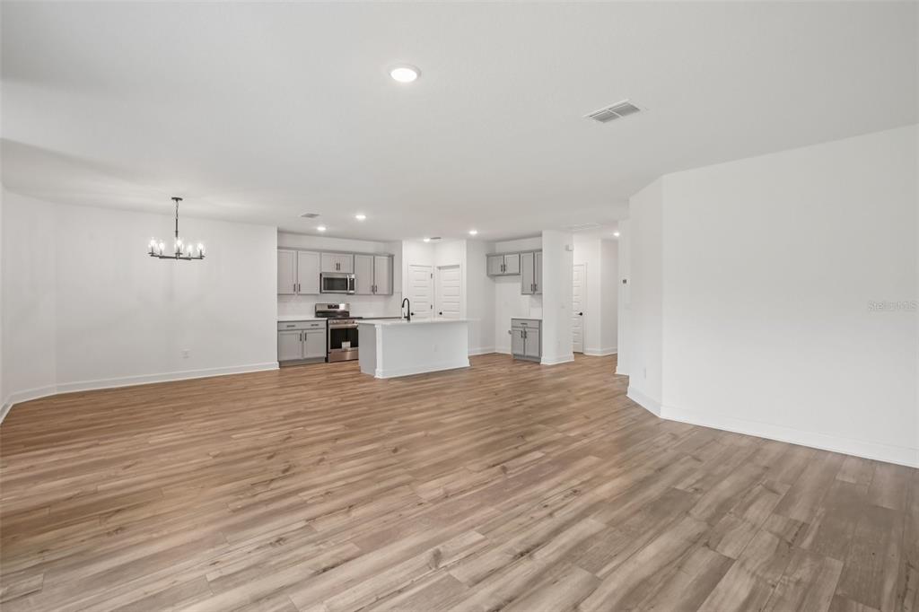 3033 Magellan Avenue Spring Hill, FL 34608 - Photo 14 of 42 a view of kitchen and empty room with wooden floor