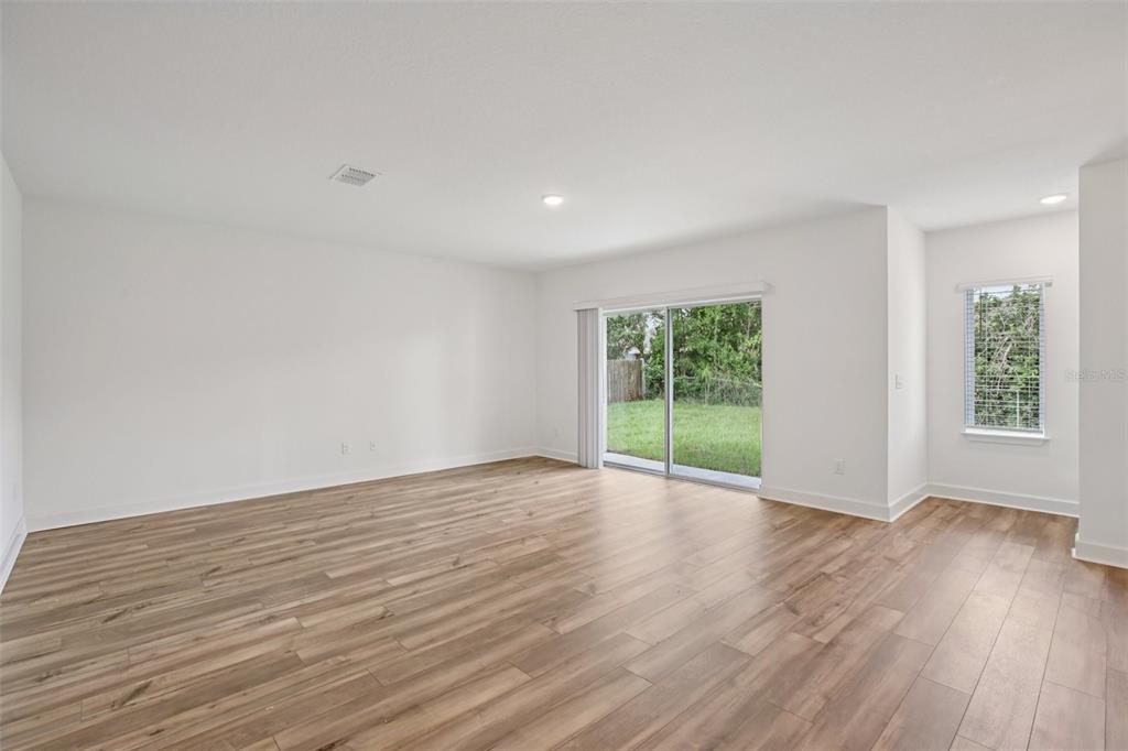 3033 Magellan Avenue Spring Hill, FL 34608 - Photo 16 of 42 a view of an empty room with wooden floor and a window
