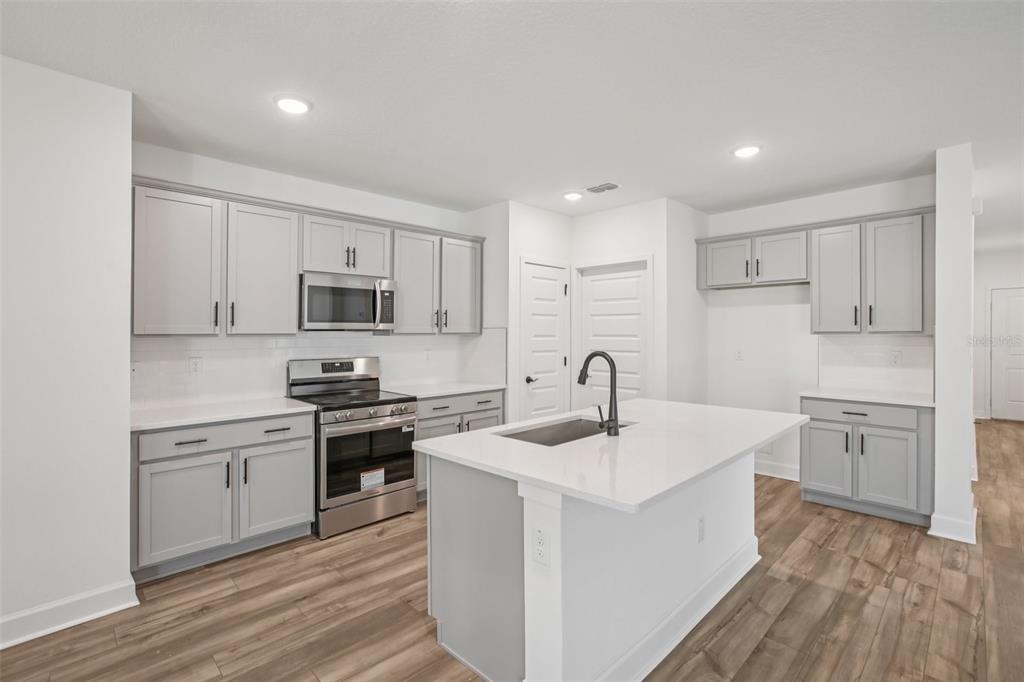 3033 Magellan Avenue Spring Hill, FL 34608 - Photo 20 of 42 a kitchen with a sink stove cabinets and refrigerator