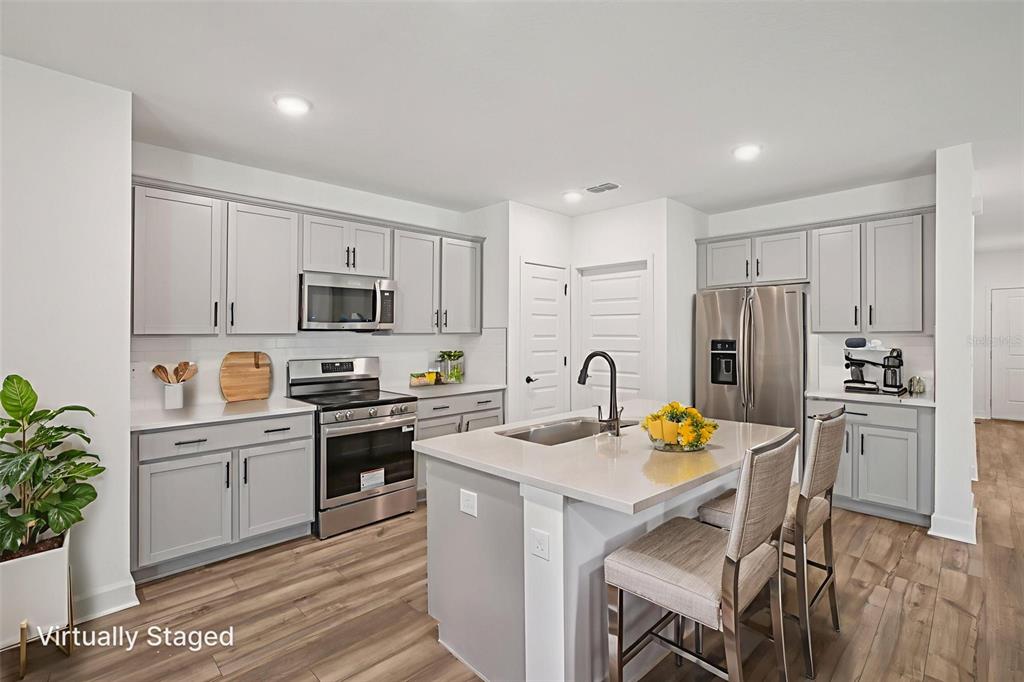 3033 Magellan Avenue Spring Hill, FL 34608 - Photo 21 of 42 a kitchen with a sink white cabinets and stainless steel appliances