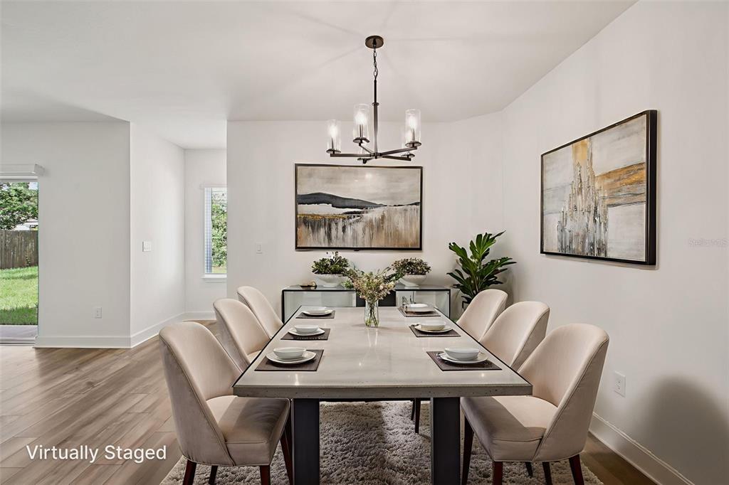 3033 Magellan Avenue Spring Hill, FL 34608 - Photo 8 of 42 a view of a dining room with furniture wooden floor and chandelier