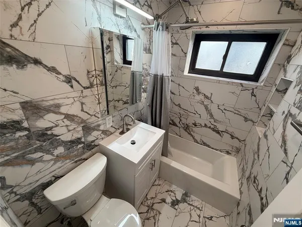 a bathroom with a bathtub a toilet and a shower