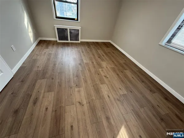 a view of a hallway with wooden floor and stairs