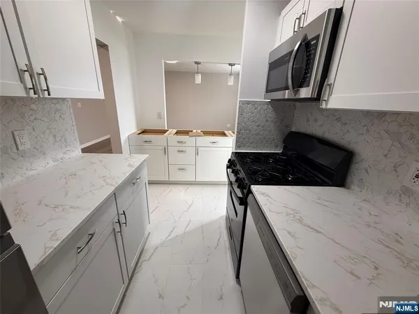 a kitchen with a sink a stove and cabinets