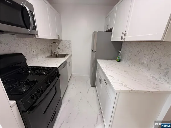a kitchen with a sink stove and cabinets