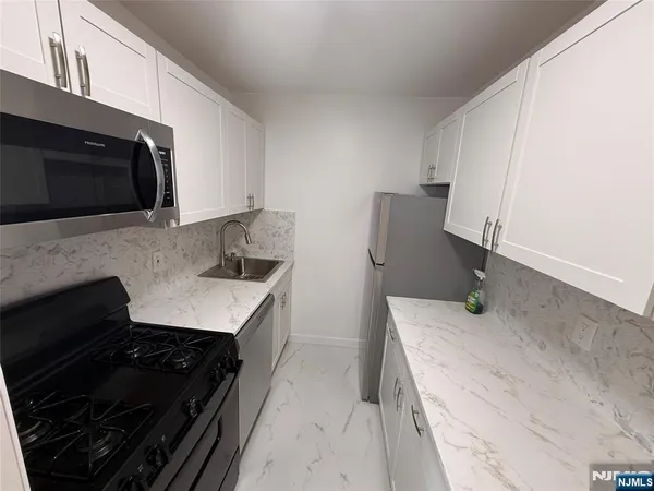 a kitchen with granite countertop a stove and a microwave