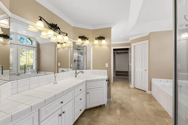 a white bath tub sitting in a bathroom next to a window