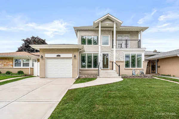 a front view of a house with a yard and garage