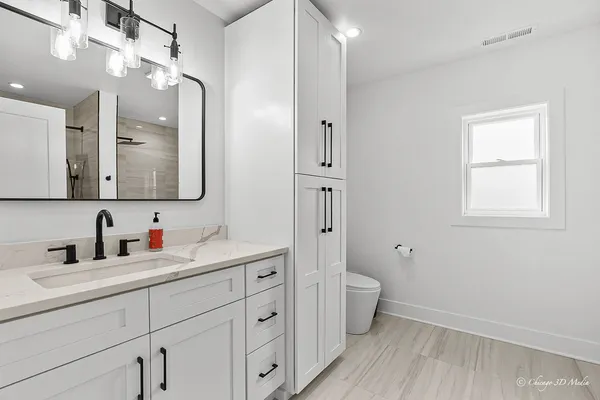 a bathroom with a double vanity sink toilet mirror and a shower
