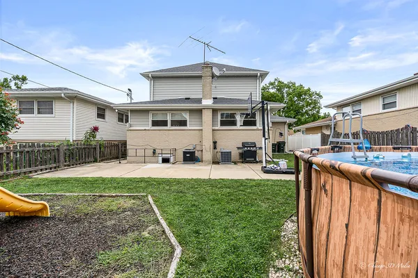 a view of a house with a yard patio and fire pit