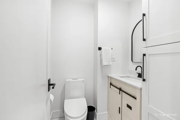 a bathroom with a granite countertop sink toilet and mirror