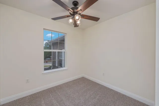 an empty room with a window and a fan