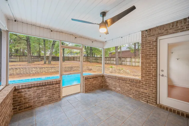 a view of an empty room with a floor to ceiling window and a ceiling fan