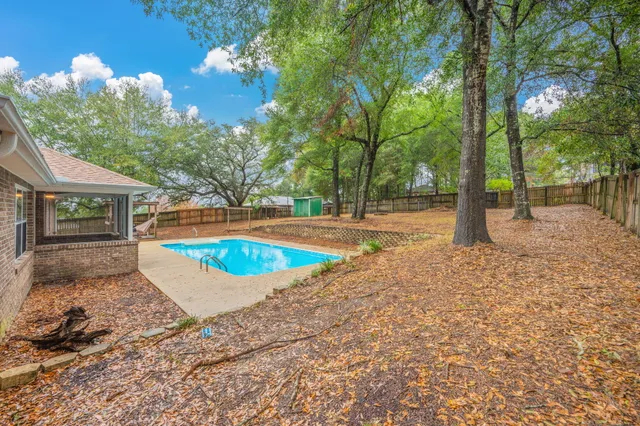 a view of a house with backyard and trees