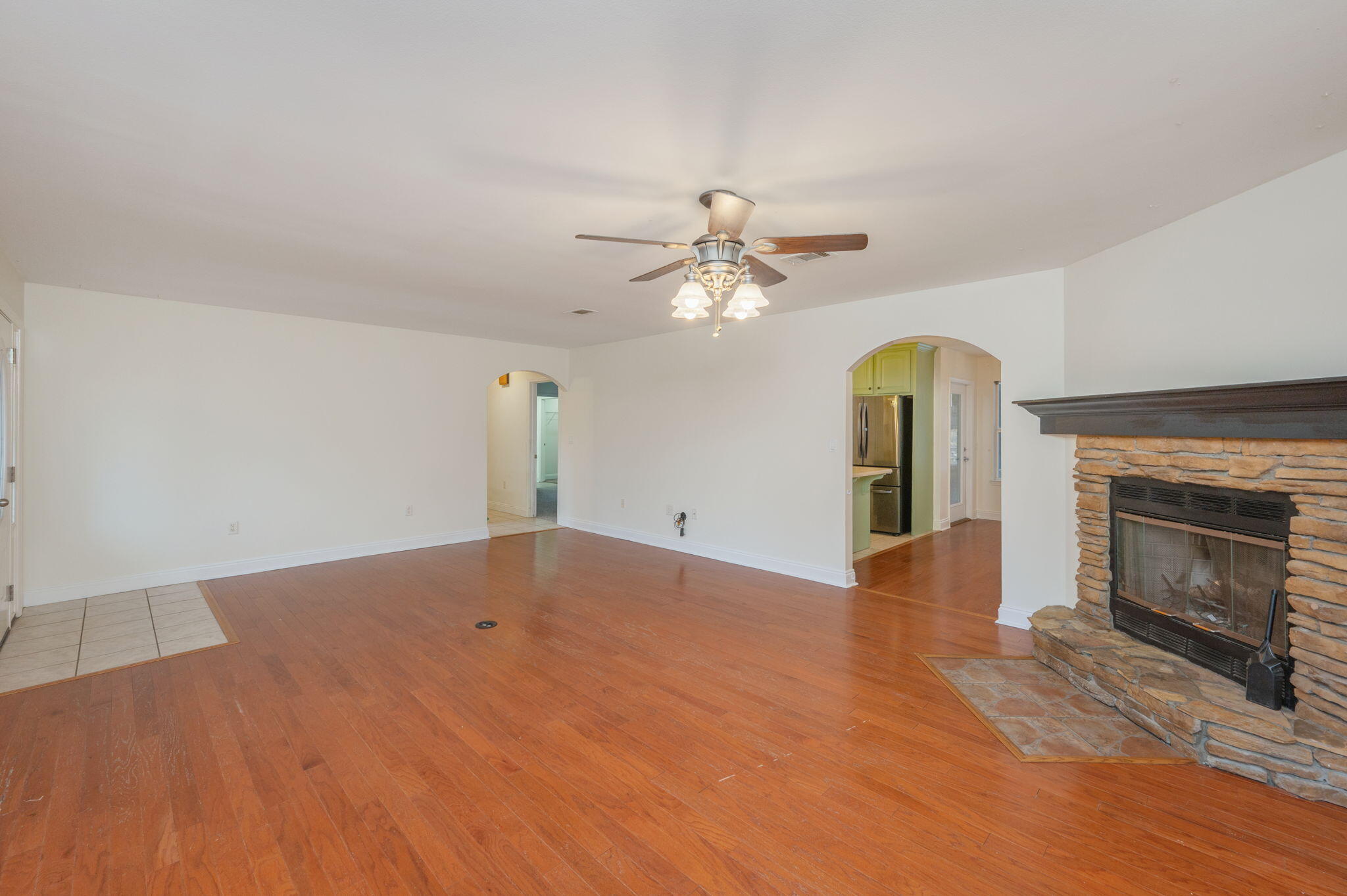 231 Seneca Trail Crestview, FL 32536 - Photo 6 of 39 an empty room with a fireplace and chandelier fan