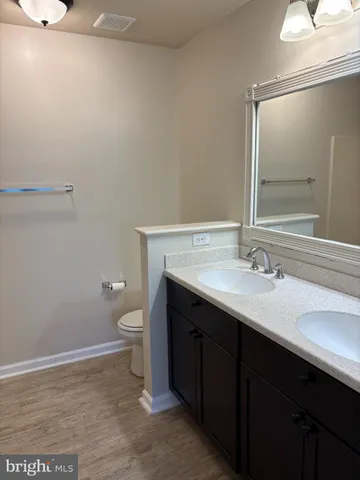 a bathroom with a sink a toilet and a mirror