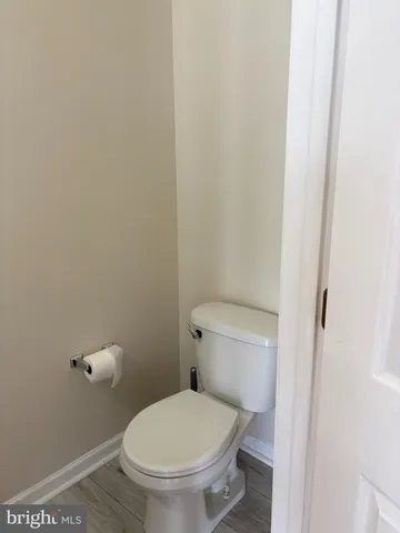 a white toilet sitting next to a white wall