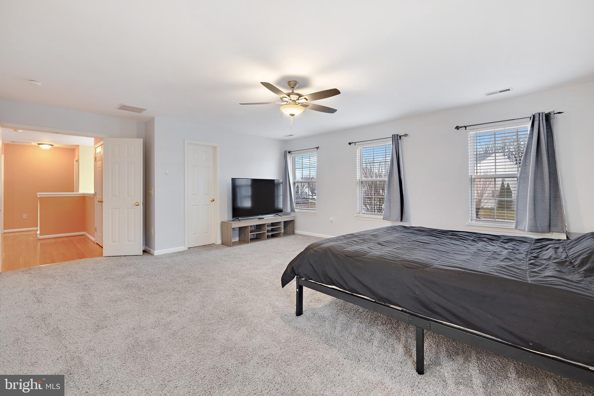 8008 Carlean Court Pasadena, MD 21122 - Photo 16 of 35 a bedroom with a bed and a flat screen tv