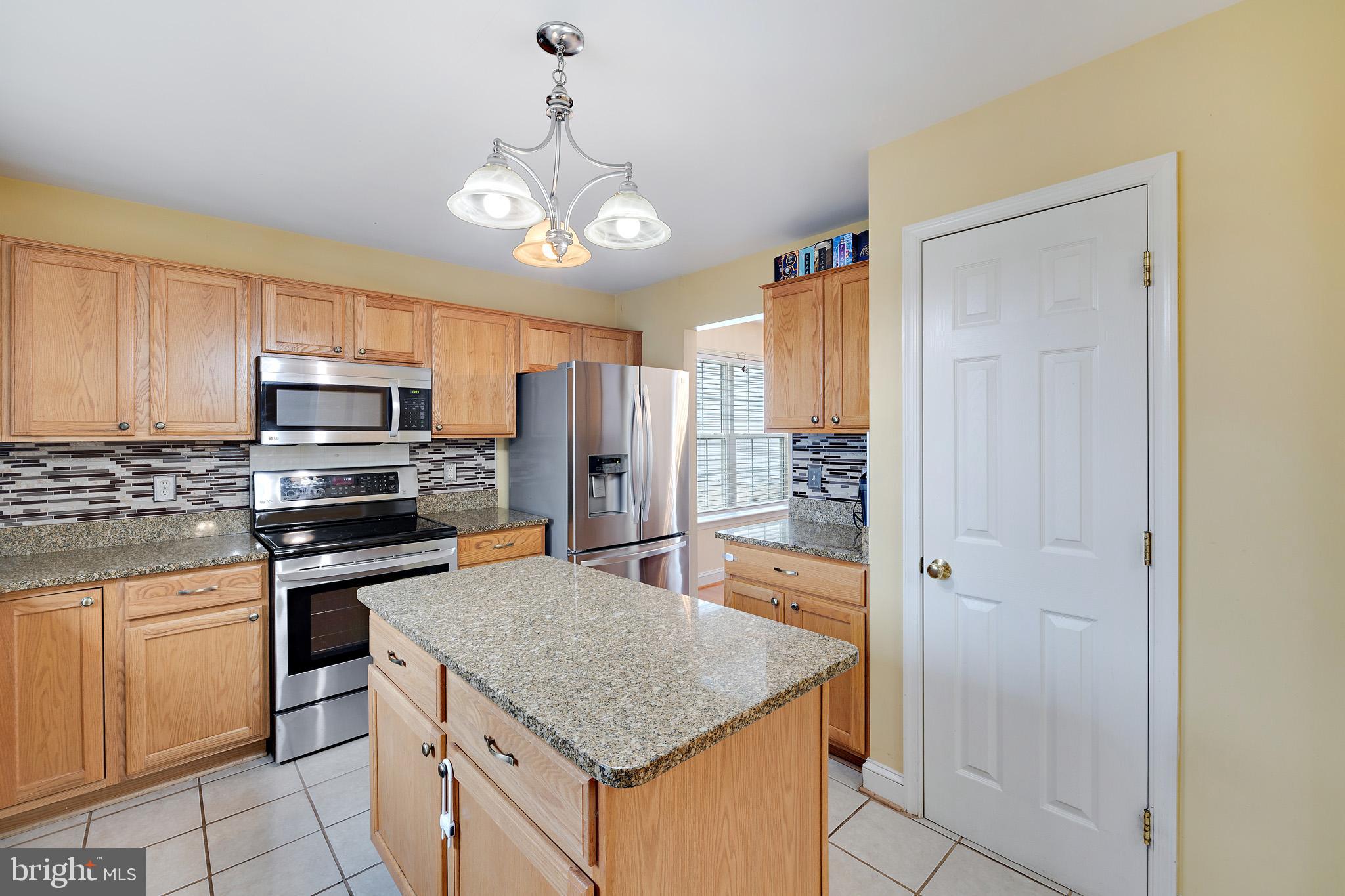8008 Carlean Court Pasadena, MD 21122 - Photo 7 of 35 a kitchen with stainless steel appliances granite countertop a refrigerator oven a sink dishwasher and white cabinets with wooden floor