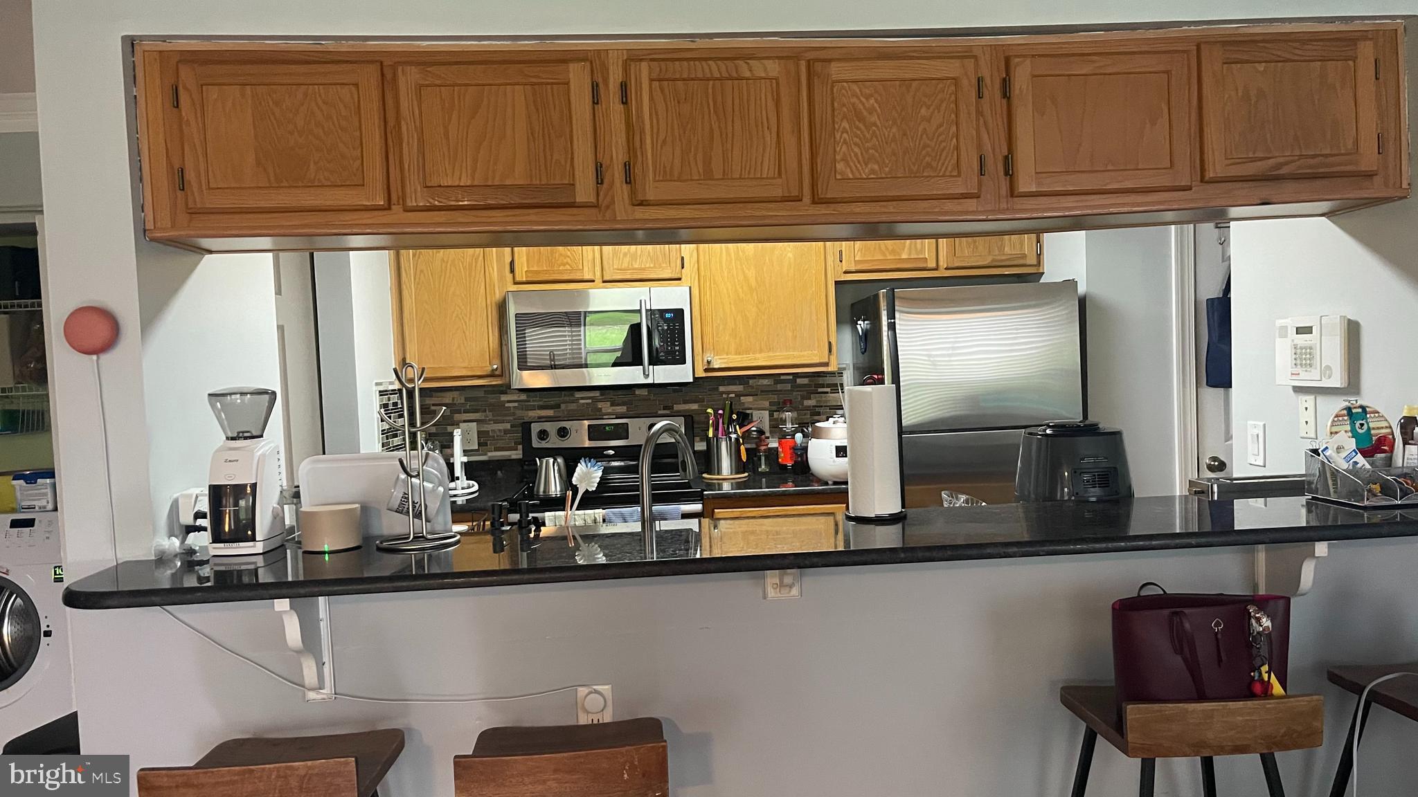 14200 Valleyfield Drive, Unit 437 Silver Spring, MD 20906 - Photo 7 of 17 a kitchen with stainless steel appliances granite countertop a refrigerator and microwave