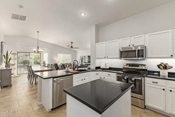 a spacious bedroom with a bed and a chandelier