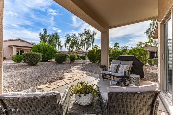 a view of a backyard with table and chairs and potted plants and large trees