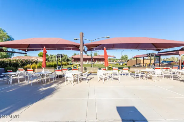 a living room with couches a table and chairs with kitchen view